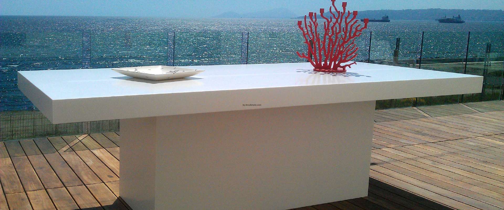 Tavolo da esterno in Corian bianco su una terrazza sul mare