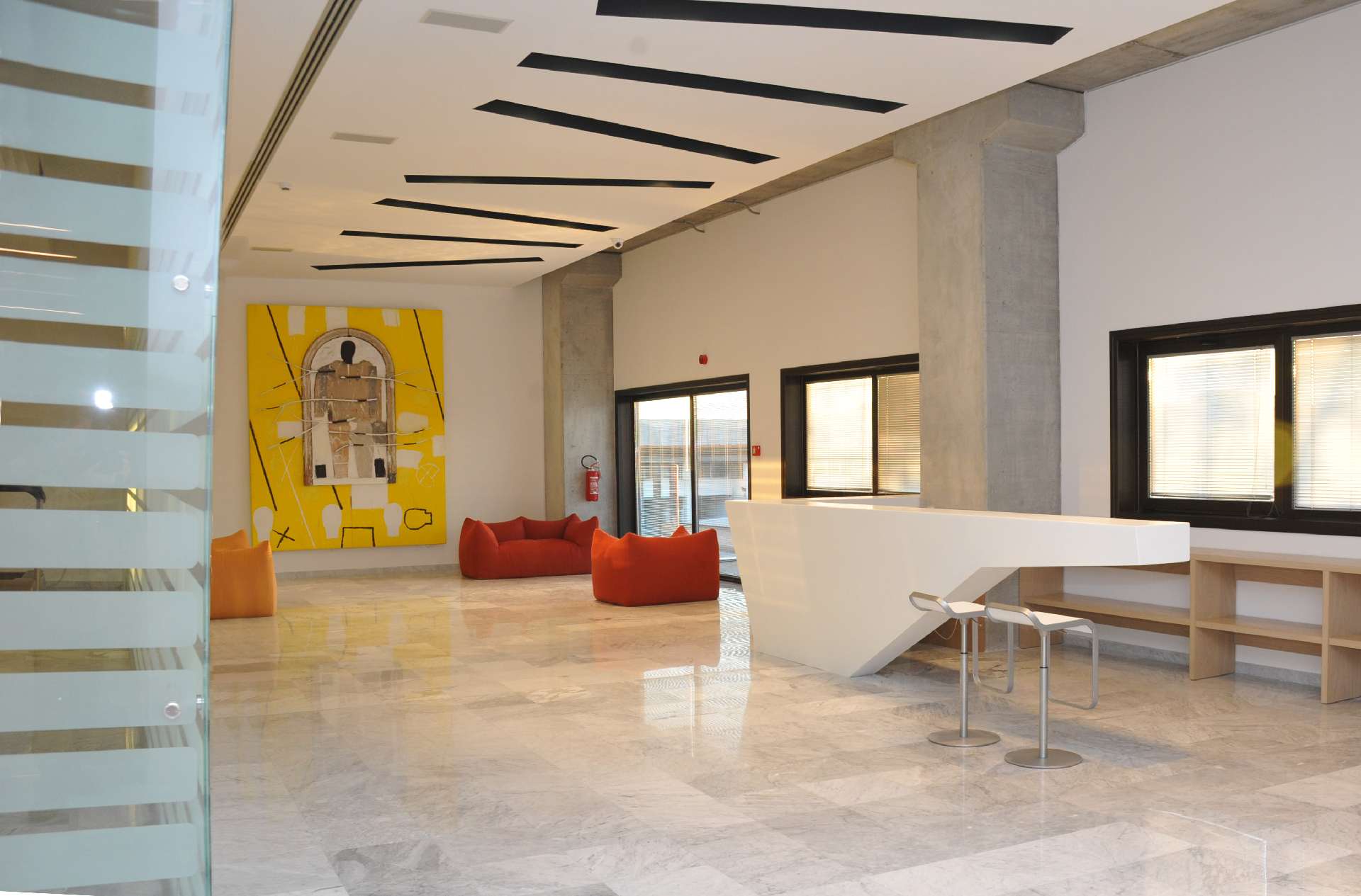 La hall Kiton con il banco in Corian e l'opera di Mimmo Paladino